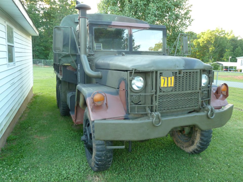 Front view of a camouflage military truck with a yellow '71' badge