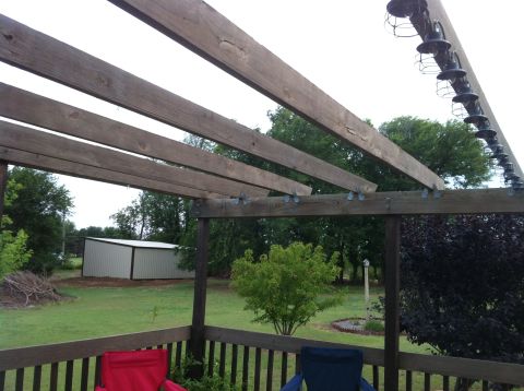 1994 Ford Bronco - A view of a backyard from a deck, a shed and a pergola overhead.