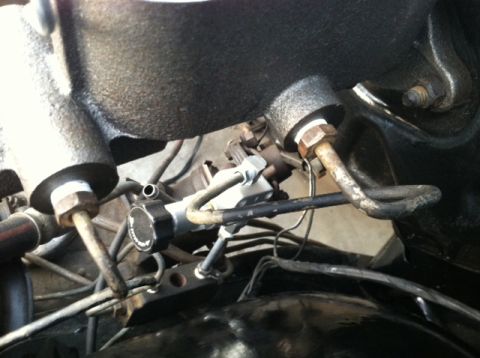 1967 Pontiac Grand Prix - Close-up view of a brake master cylinder, likely from an older vehicle, showing metal brake lines and a black cap with some text.