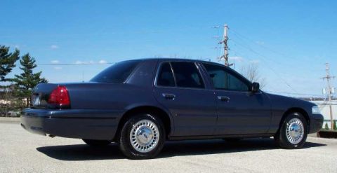 1998 Ford Crown Victoria - This 1998 Ford Crown Victoria is shown from its rear three-quarter angle under a clear blue sky.