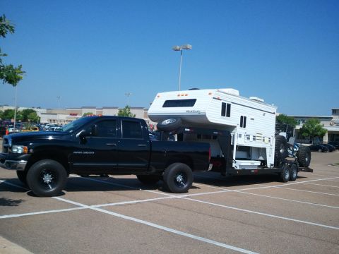 1967 Ford Mustang - Black Dodge Ram 3500 pickup truck towing a camper and a trailer with a vehicle on the trailer.