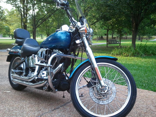 Blue motorcycle with chrome accents parked on a paved surface