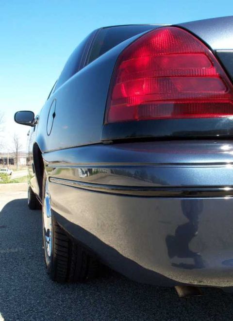 1998 Ford Crown Victoria - Rear quarter view of a dark blue 1998 Ford Crown Victoria sedan under a clear blue sky.