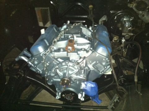 1967 Pontiac Grand Prix - Engine assembly with chrome valve covers and intake manifold, suspended by chains.