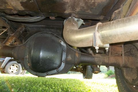 1987 Ford F-250 - The photo shows the rear axle and exhaust system of a truck, with another vehicle visible in the background.