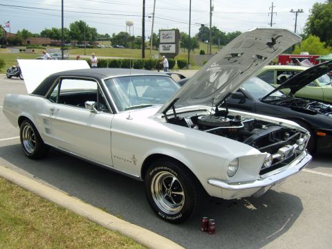 2007 Ford Mustang - A classic white 1967 Ford Mustang is displayed with its hood open at an outdoor car show.