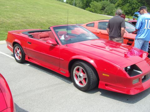 2007 Ford Mustang - This red convertible features Z28 badging and a sporty body style, seen at a car show.