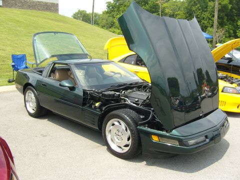 2007 Ford Mustang - A green Corvette is displayed with its hood and rear hatch open, revealing the engine compartment and interior.