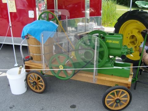 2007 Ford Mustang - A vintage engine display a John Deere motor and a wooden barrel on a wheeled cart.