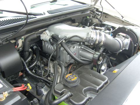 2007 Ford Mustang - Close-up of a supercharged engine bay with various components visible.