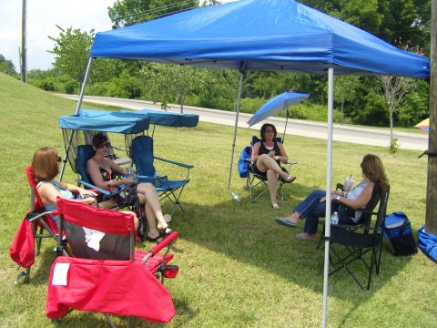 2007 Ford Mustang - People enjoy an outdoor gathering, seeking shade under pop-up tents on a sunny day.