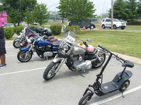 2007 Ford Mustang - Several motorcycles and an electric scooter are parked in a lot, with a white SUV visible in the background.
