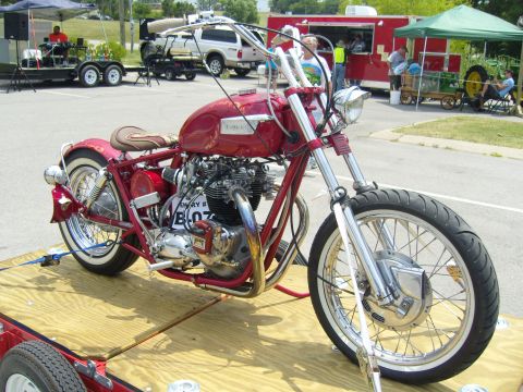2007 Ford Mustang - A custom red motorcycle with whitewall tires and chrome accents is displayed on a wooden trailer.