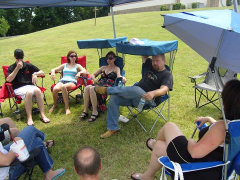 2007 Ford Mustang - People gathered outdoors, seated in lawn chairs beneath a canopy on a sunny day.