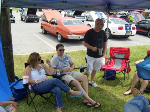 2007 Ford Mustang - A white Ford Mustang with blue racing stripes is parked at an outdoor car show.