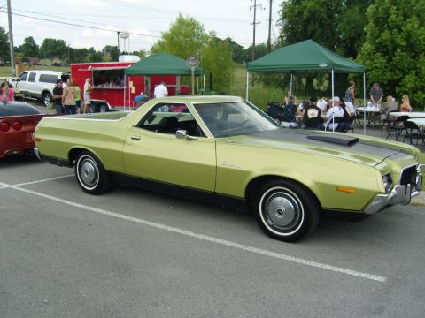 2007 Ford Mustang - A lime green 1972 Ford Ranchero is parked at an outdoor event with people gathered under tents in the background.
