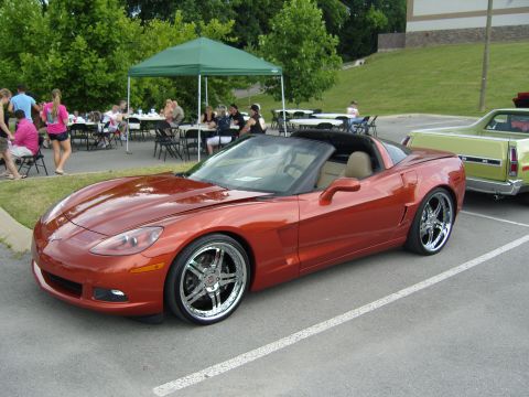 2007 Ford Mustang - Orange convertible sports car with custom wheels parked at an outdoor event.