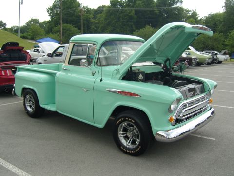 2007 Ford Mustang - A classic Chevrolet pickup truck is displayed with its hood open at an outdoor car show.
