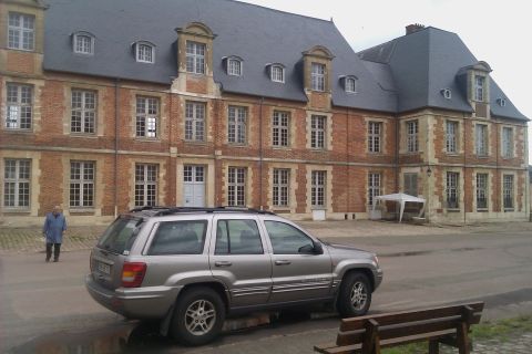 1991 Ford LTD Crown Victoria - Silver Jeep Grand Cherokee seen parked in front of a large brick building with a grey roof.
