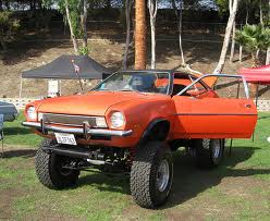 1976 Ford Bronco - This lifted Ford Pinto is shown with its doors open, parked on a grassy area.