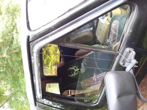 1986 Ford Bronco - Interior of a dark SUV with camouflage seat covers and a decal on the rear window.