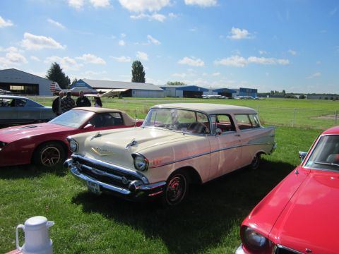 1991 Ford LTD Crown Victoria - A classic 1957 Chevrolet Nomad station wagon is displayed at an outdoor event with airplanes in the background.