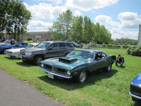 1991 Ford LTD Crown Victoria - A green 1970 Plymouth Barracuda is displayed at a car show alongside other vehicles.