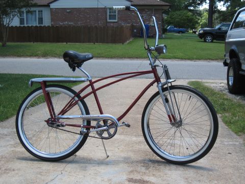 1994 Ford Bronco - A maroon cruiser bicycle is parked on a driveway next to a vehicle.