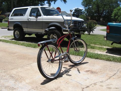1994 Ford Bronco - A white 1994 Ford Bronco is parked next to a red cruiser bicycle on a driveway.