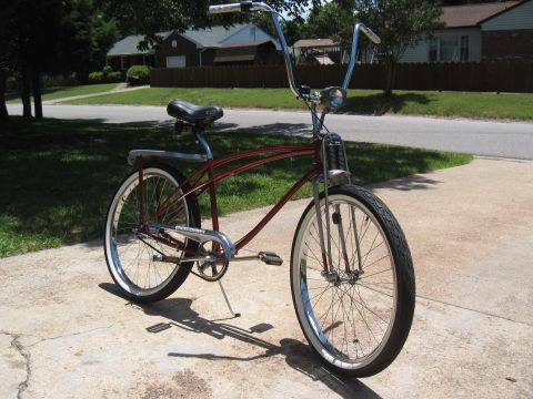 1994 Ford Bronco - Cruiser bicycle with chrome handlebars and whitewall tires sits on a concrete driveway.