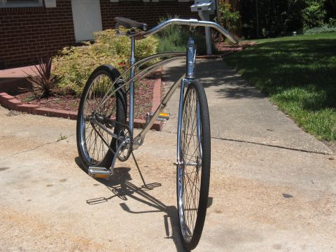 1994 Ford Bronco - A vintage-style bicycle with a chrome frame and wide handlebars is parked on a concrete walkway.