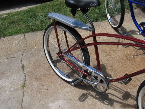 1994 Ford Bronco - Close-up of a red cruiser bicycle's rear wheel and frame, with another bicycle in the background.