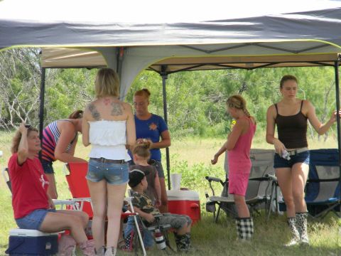 1989 Ford Bronco - A group of people are socializing under a canopy at an outdoor event.