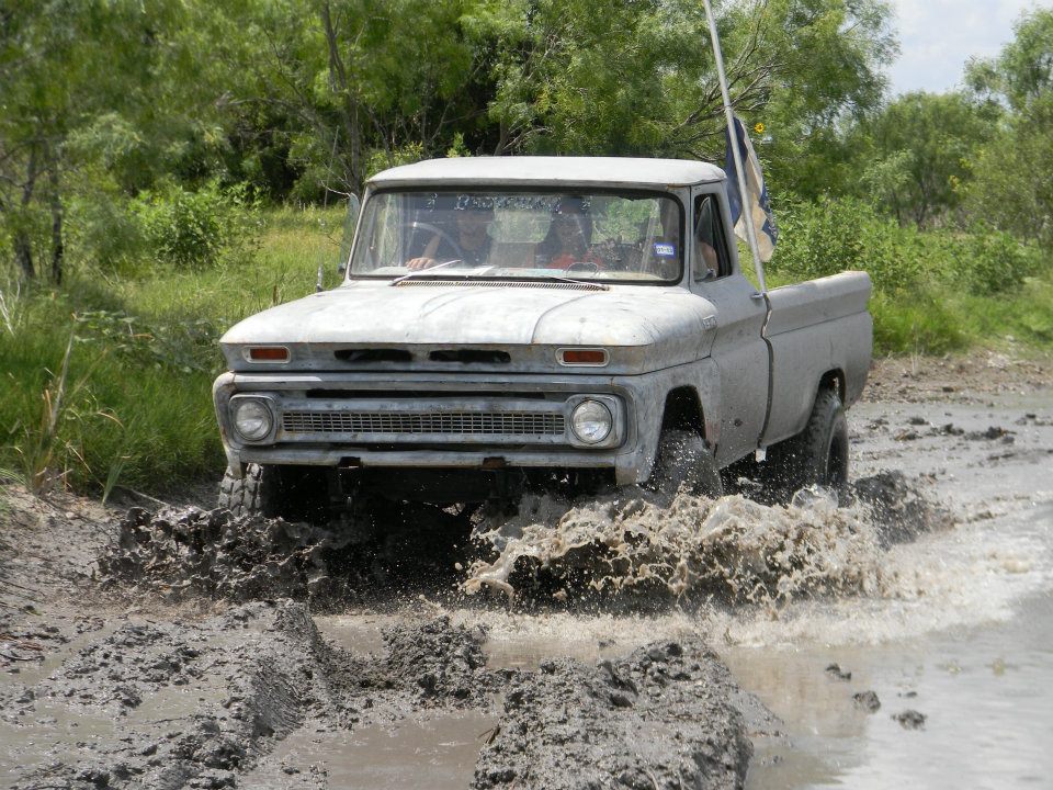 1964 Chevrolet C10 pickup truck splashing through mud