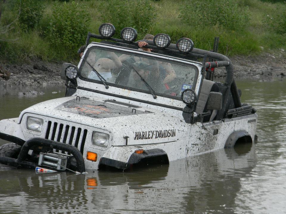 White Jeep with Harley-Davidson decal stuck in water
