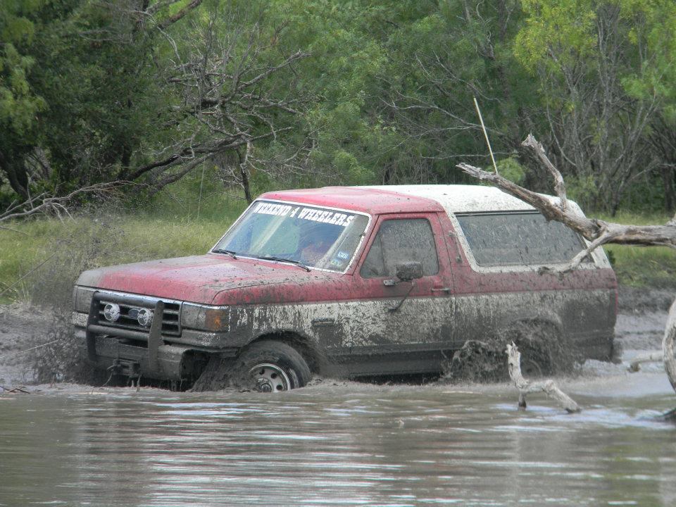 1989 Ford Bronco stuck in mud, front bull bar visible