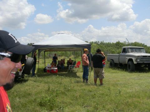 1989 Ford Bronco - A classic pickup truck is seen in a field with people gathered under a canopy.