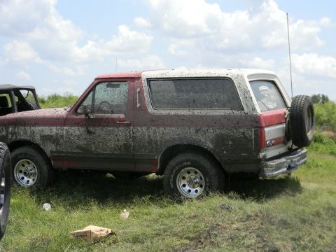 1989 Ford Bronco - This SUV is covered in mud, suggesting it has been off-roading.