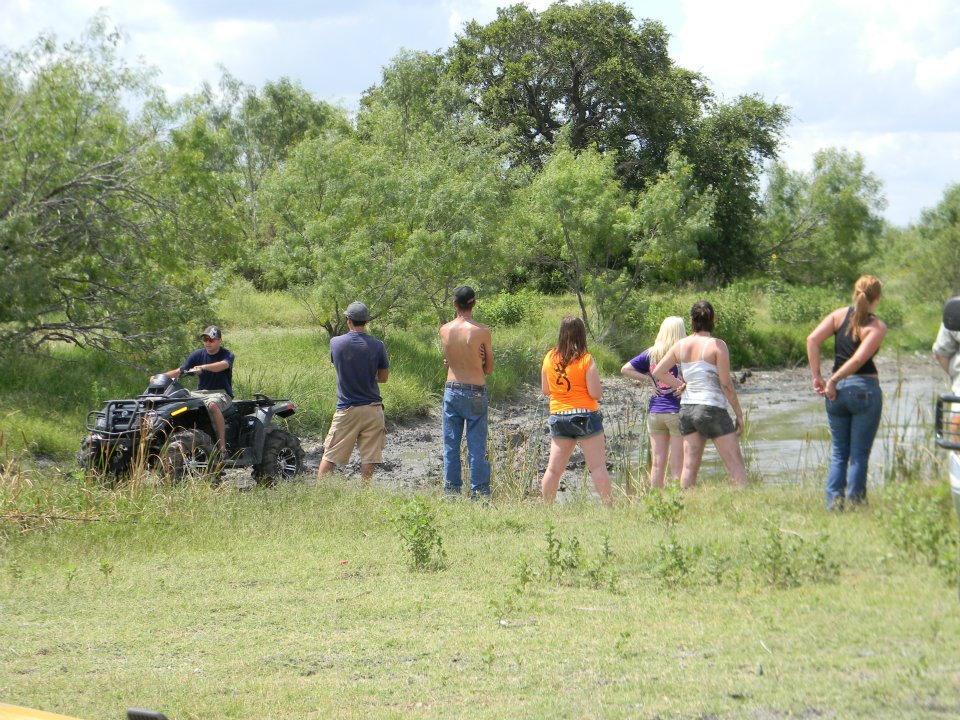 ATV in mud with people watching