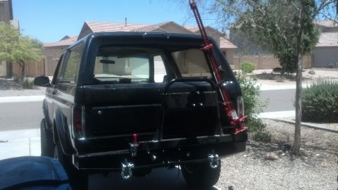 1995 Ford Bronco - This black Ford Bronco features an aftermarket rear bumper and a Hi-Lift jack mounted to the spare tire carrier.