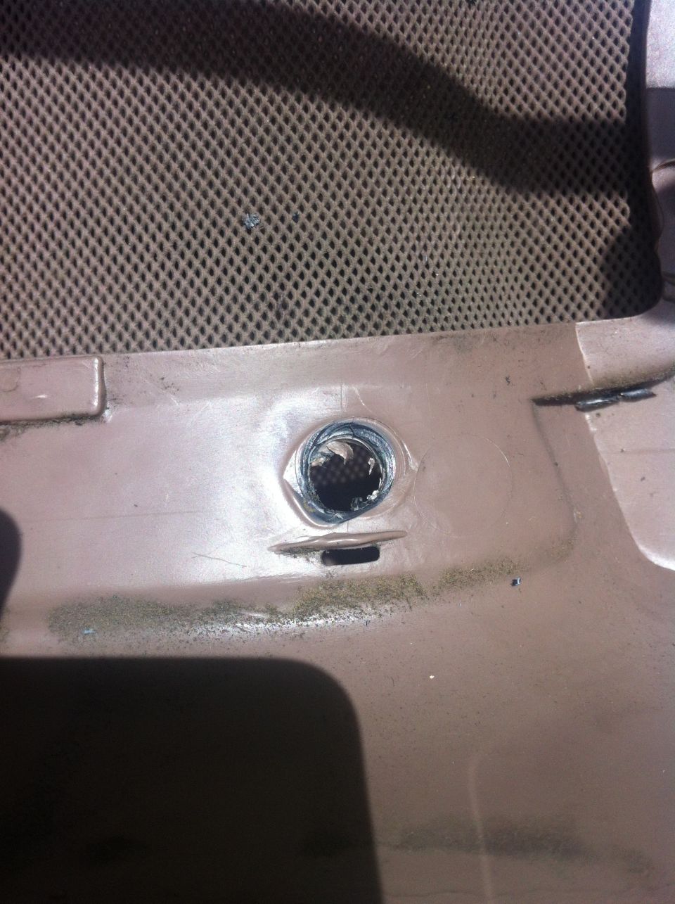 Interior trim with a damaged mounting hole and a textured speaker grille