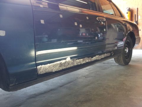 1994 Mercury Grand Marquis - This dark blue sedan shows significant rust damage and repair work along its lower body panels.