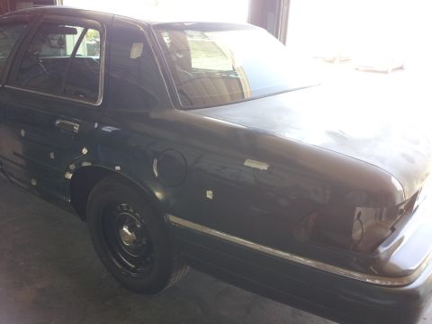 1994 Mercury Grand Marquis - Side view of a 1994 Mercury Grand Marquis, showing some areas with tape on the bodywork.
