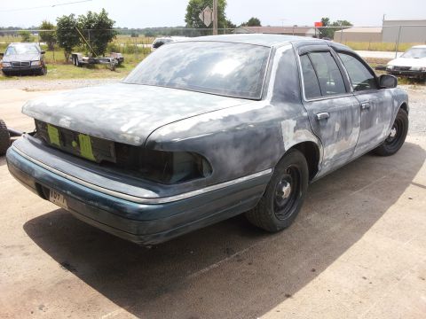 1994 Mercury Grand Marquis - A sedan in need of repair sits outdoors with other vehicles in the background.