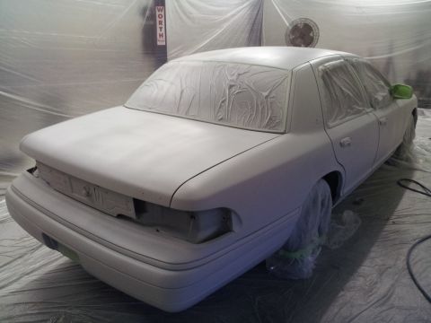 1994 Mercury Grand Marquis - A white sedan is prepared for painting, covered in masking paper.
