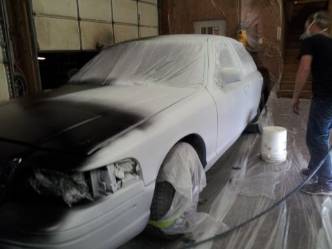 1994 Mercury Grand Marquis - A car is being prepped for painting inside a workshop, with a person in the background.