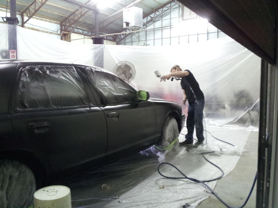 1994 Mercury Grand Marquis being painted in a spray booth, windows covered with plastic