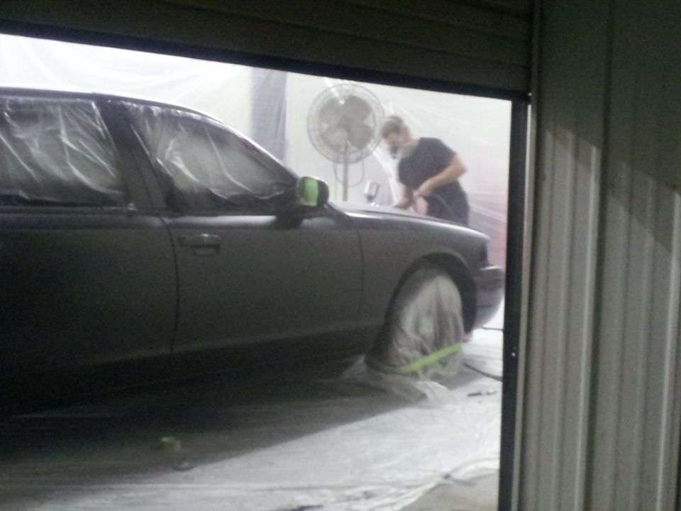 1994 Mercury Grand Marquis in a paint booth with a person working on it