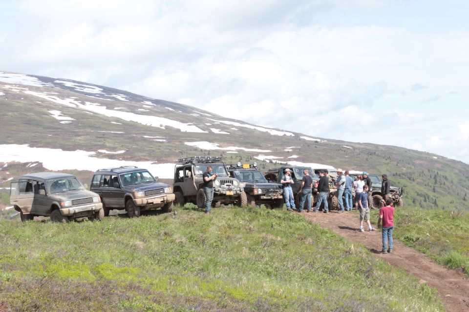 Off-road vehicles and people gathered on a mountain road