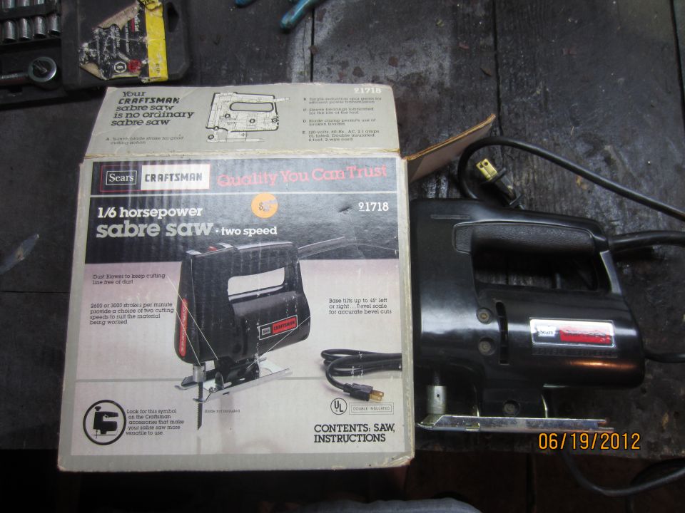 Craftsman 1/6 horsepower sabre saw with its box. Saw is black with red accents. Box shows diagram of saw and lists features